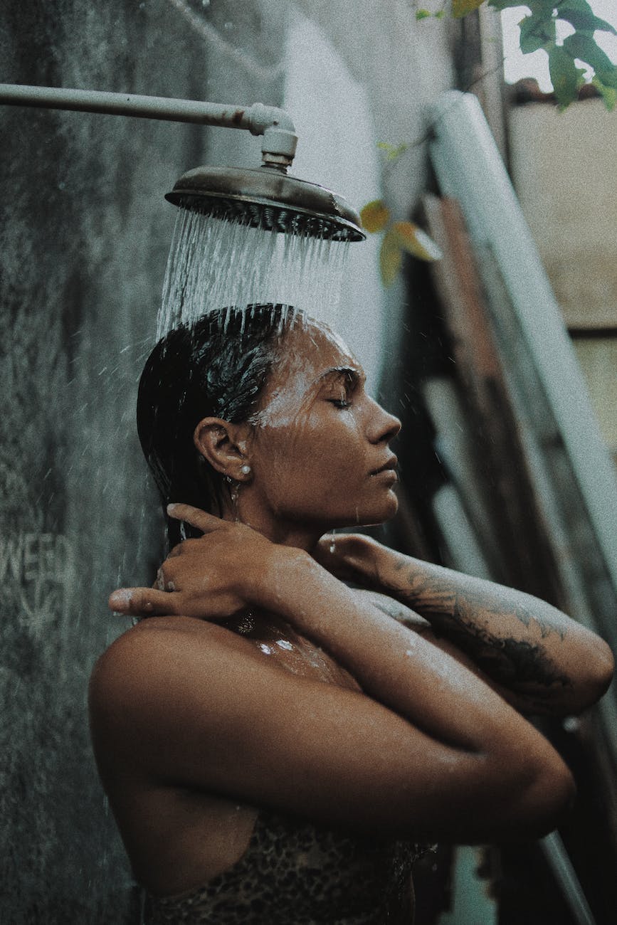 a tattooed woman taking a shower